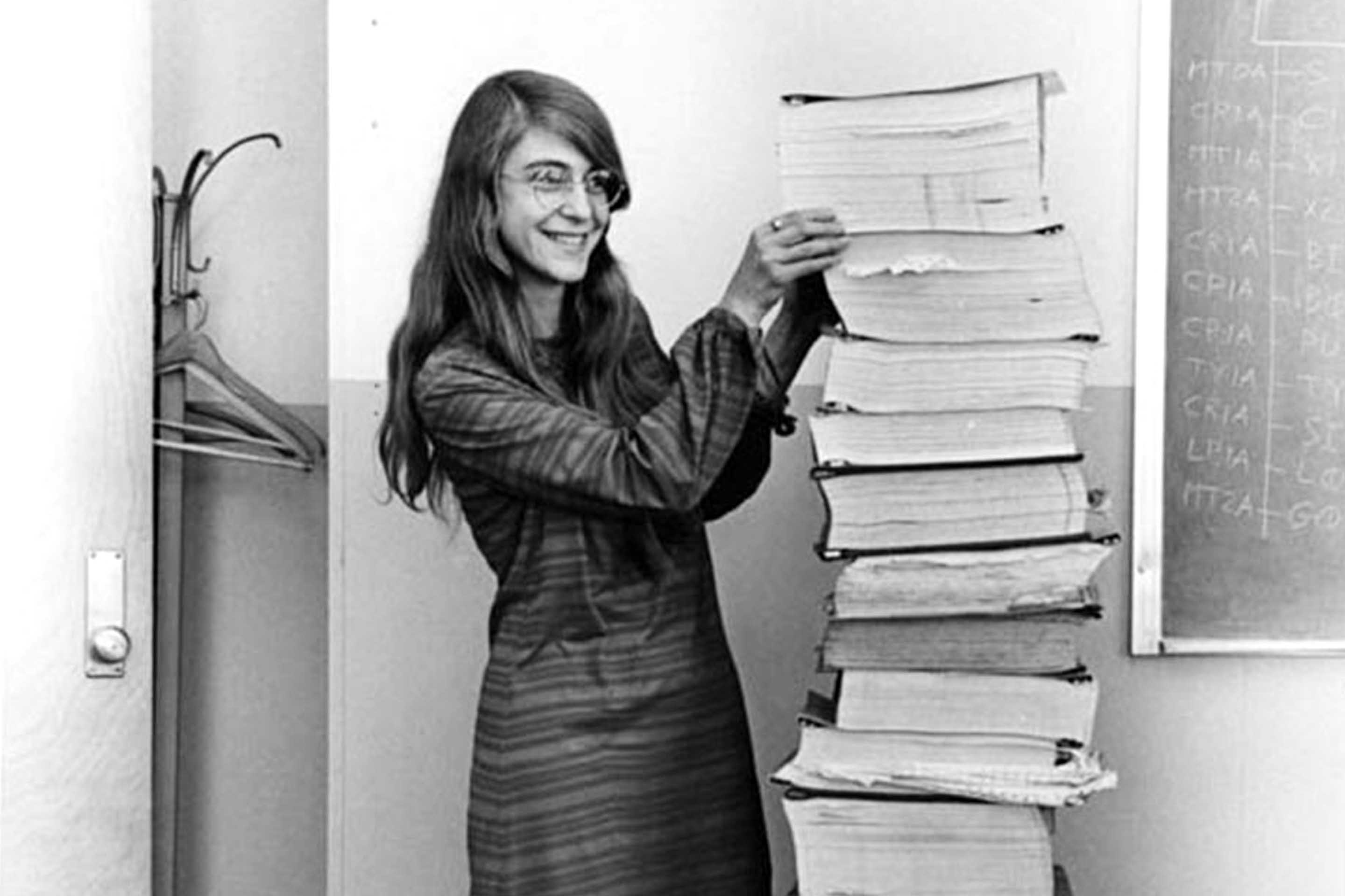 Margaret Hamilton next to a pile of books