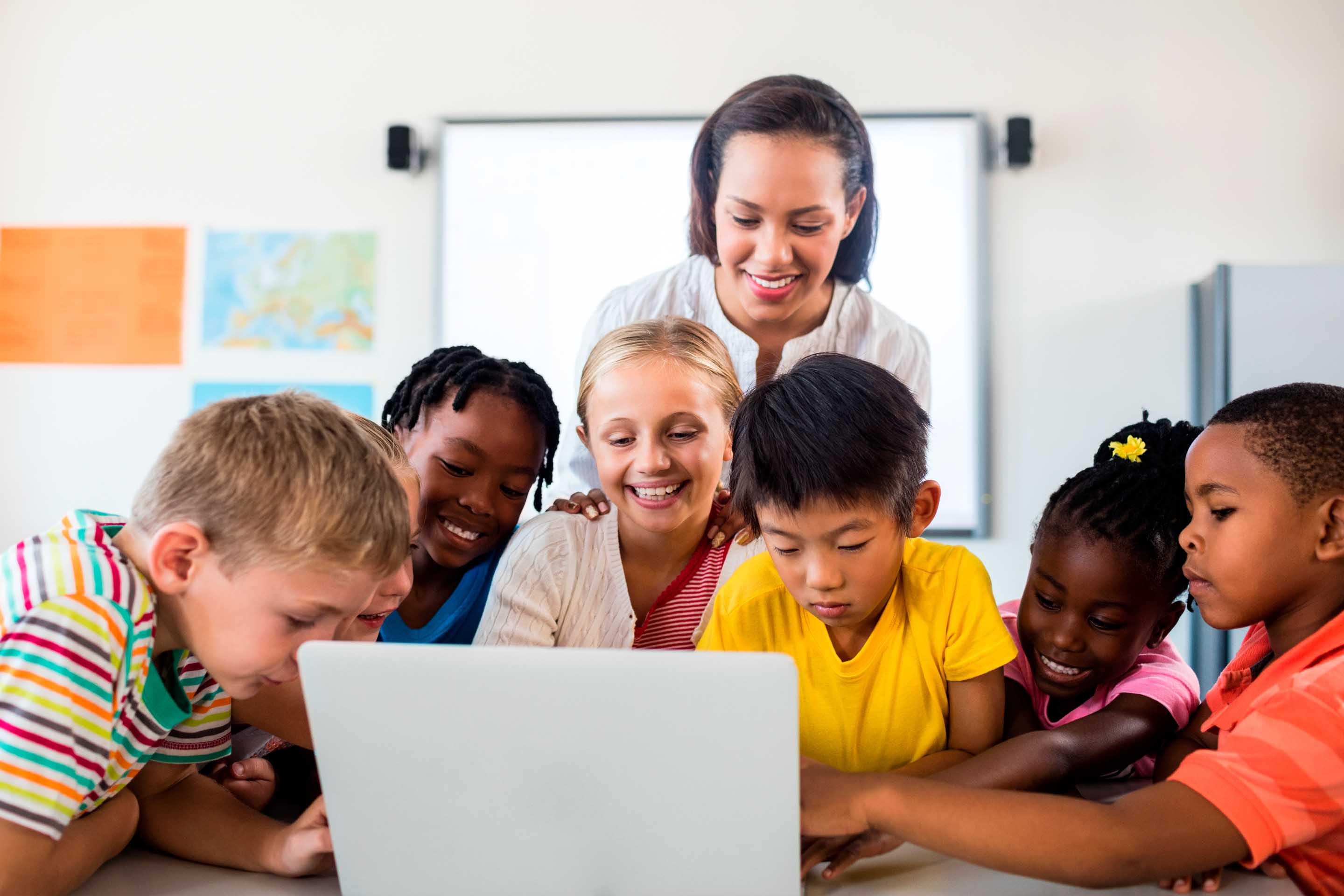 niños y entrenador mirando una computadora portátil