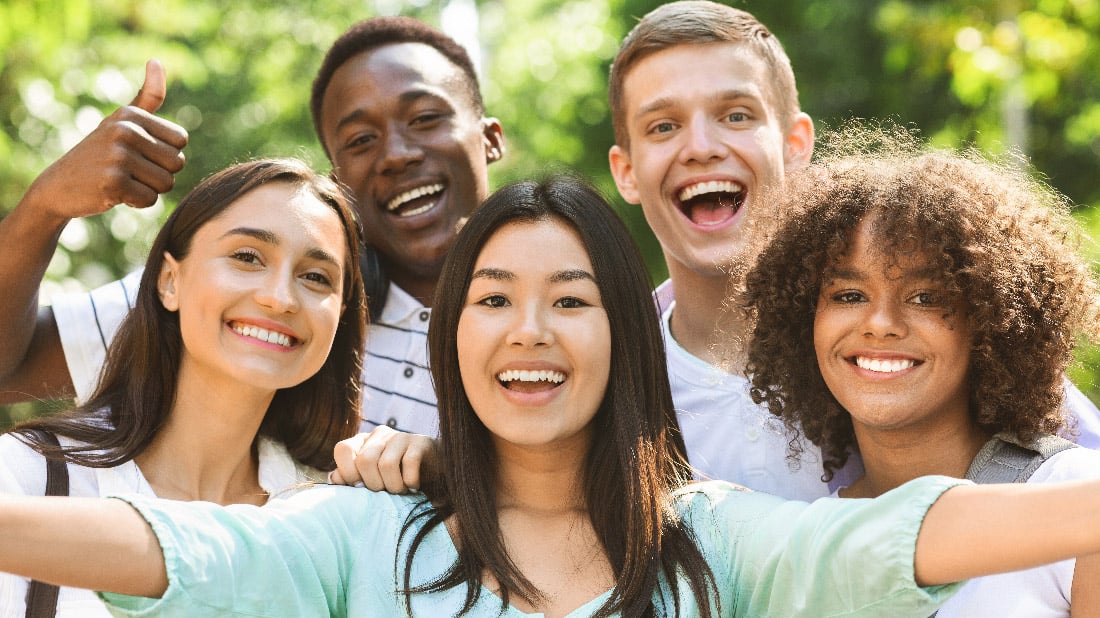 groupe d'adolescents souriants à l'extérieur