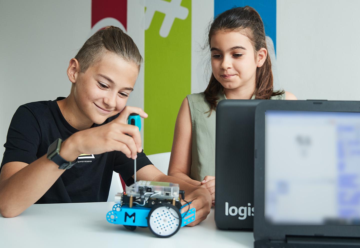 garçon et fille travaillant sur un petit robot