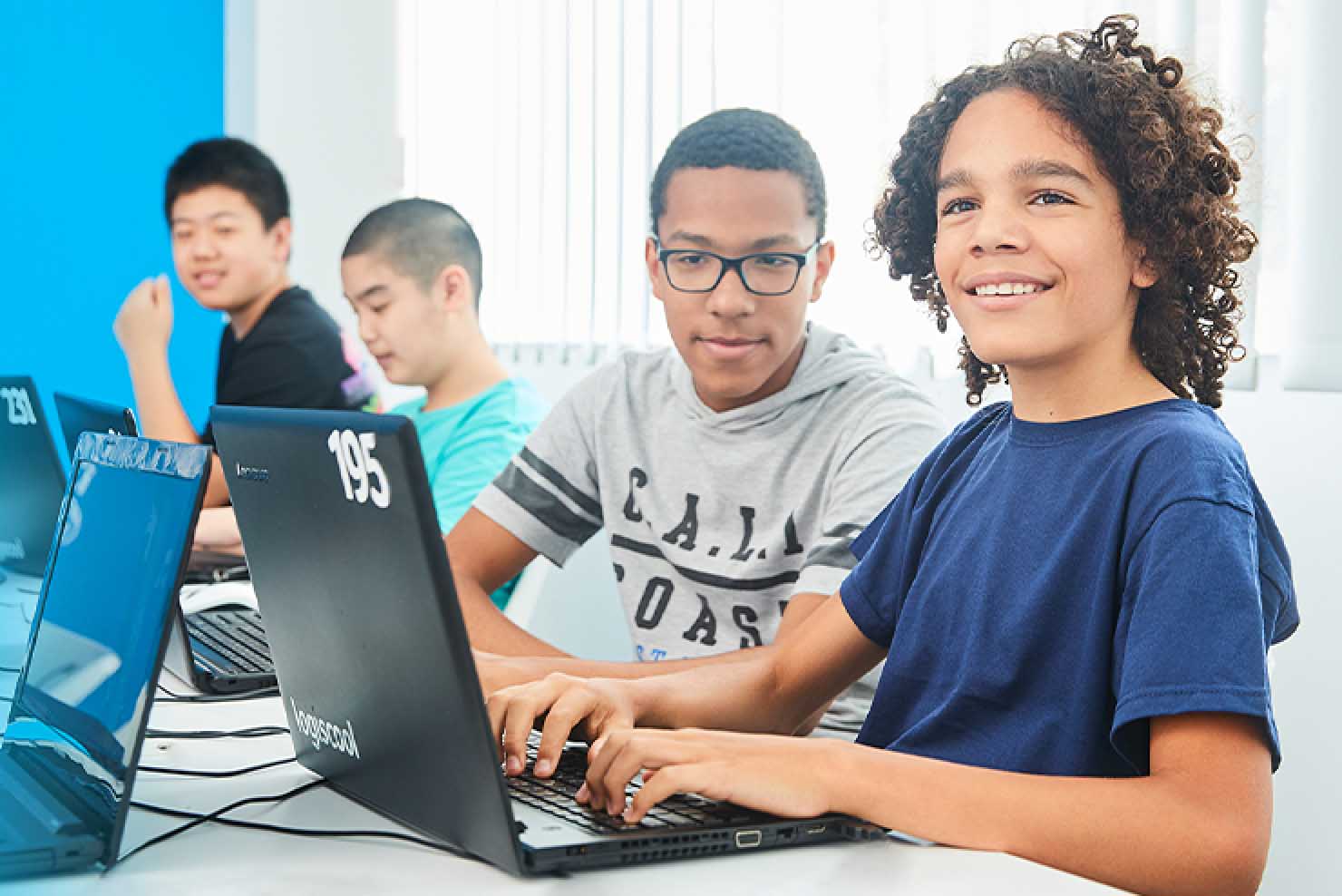 garçons devant un ordinateur portable en train de coder