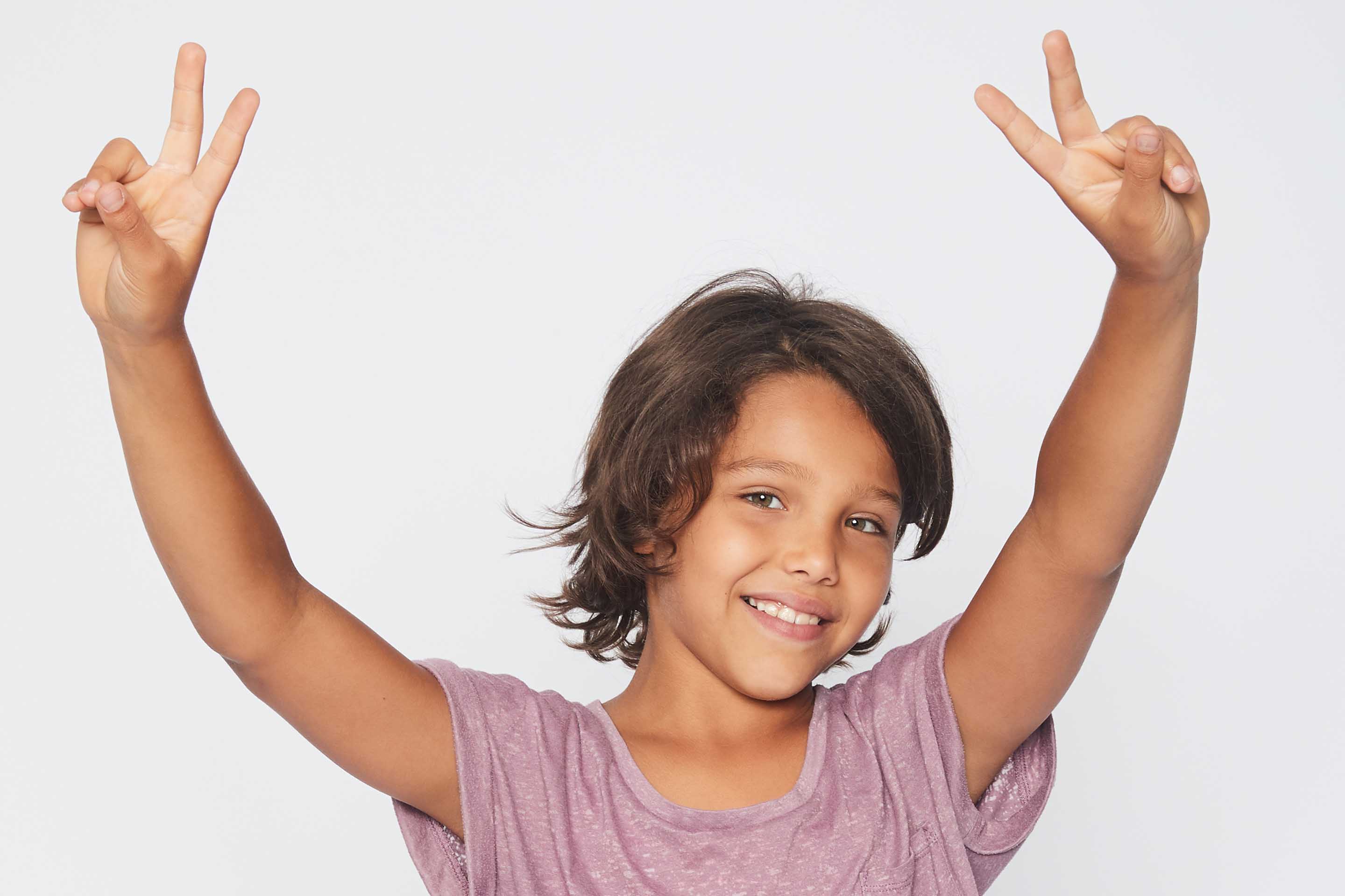 petite fille en t-shirt rose montrant des signes de victoire